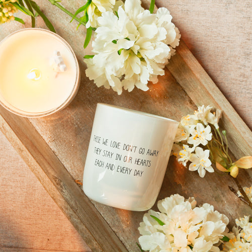 Kaars met daarop de tekst: "Those we love don't go away they stay in our hearts each and every day".