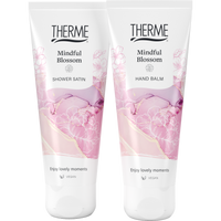 Therme Mindful Blossom Shower Satin douchegel en Hand Balm handcrème in witte tubes met roze bloemendessin. Twee verzorgingsproducten voor een ontspannen momentje voor jezelf.